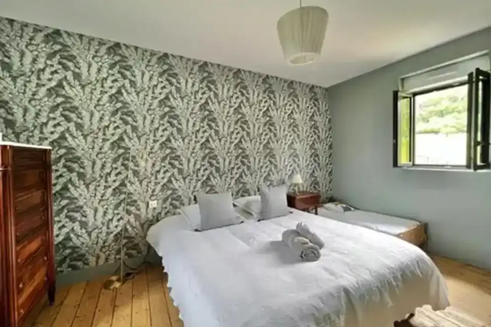 ferme-de-benerville-chambre-lit-double Chambre de la Ferme de Bénerville avec grand lit double et meuble en bois, décoration chaleureuse
