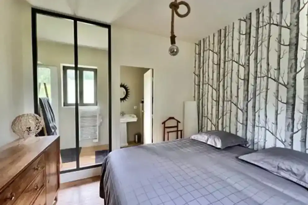 ferme-de-benerville-chambre-rangement Chambre de la Ferme de Bénerville avec rangements intégrés et décoration murale représentant une forêt