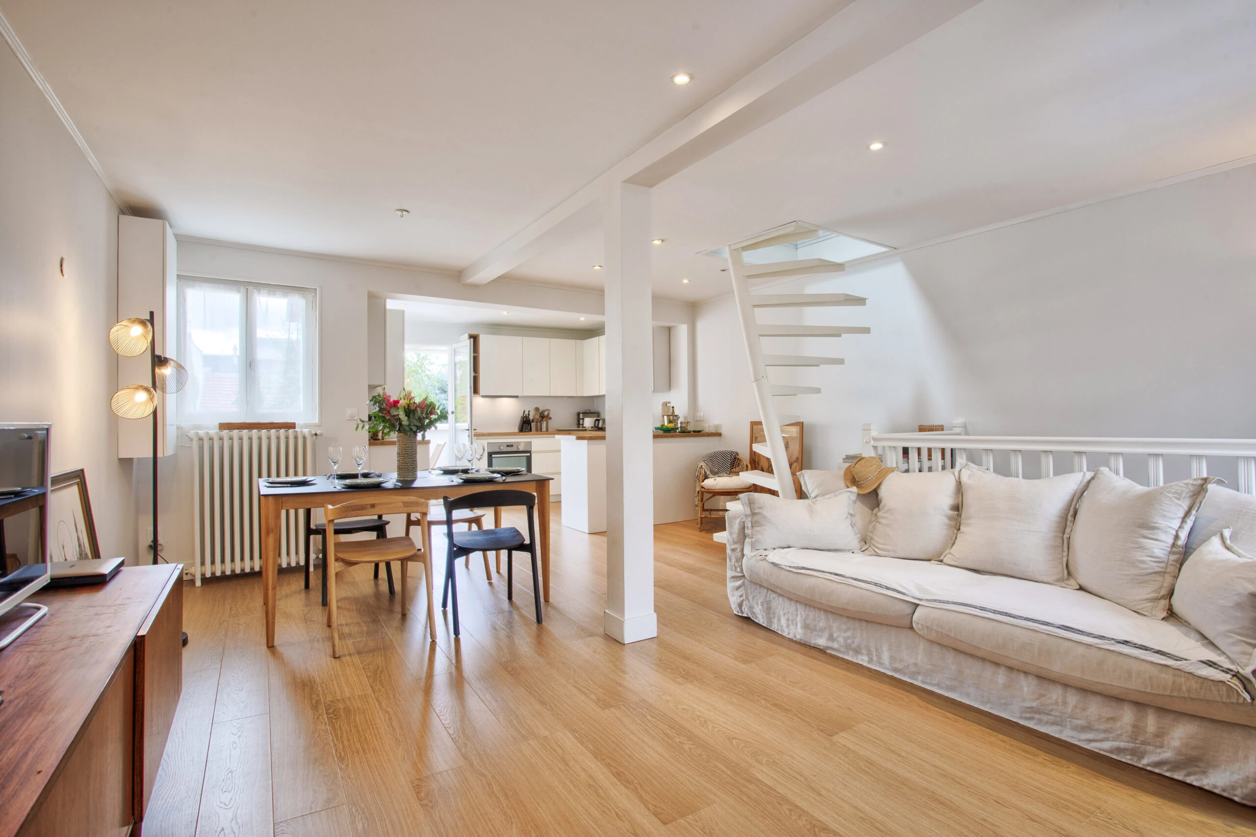 Pièce de vie ouverte avec cuisine, salle à manger et salon – maison Laguna Vue d’ensemble de la pièce de vie avec salon confortable, coin repas et cuisine ouverte – maison Laguna