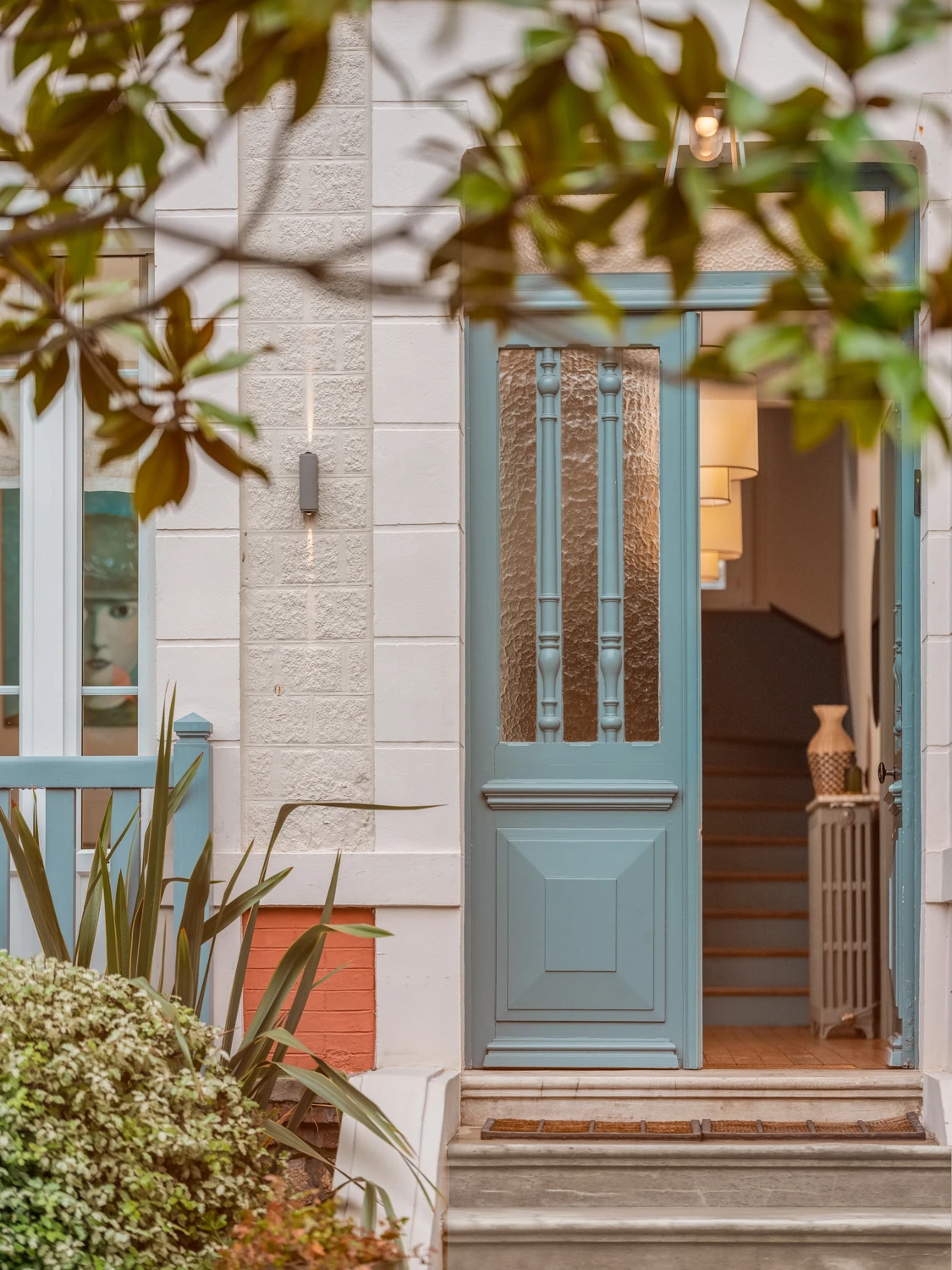 Entrée élégante et végétation – Villa Berry Porte d'entrée bleue encadrée de plantes et détails architecturaux raffinés.