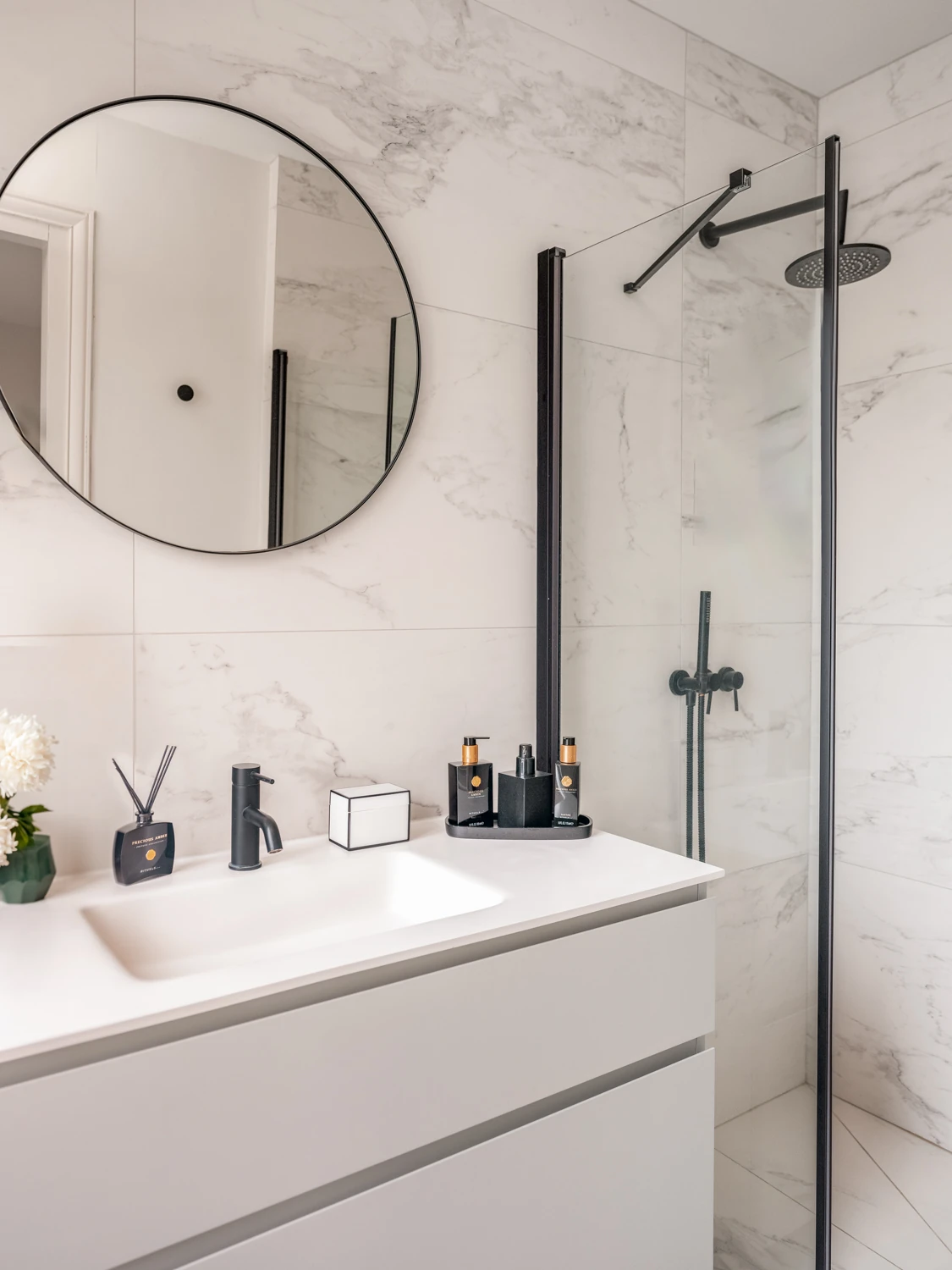 Salle de bain marbrée et design – Villa Berry Douche italienne et meuble vasque blanc dans un décor de marbre blanc.