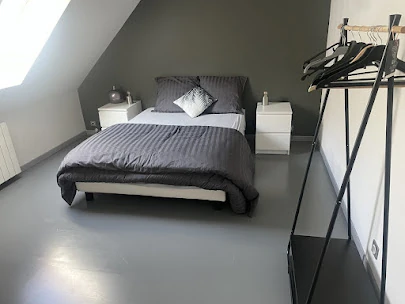 Chambre grise sous combles – Les Glycines Pont L’Evêque Chambre avec lit double et sol gris moderne, située à l’étage sous combles dans Les Glycines
