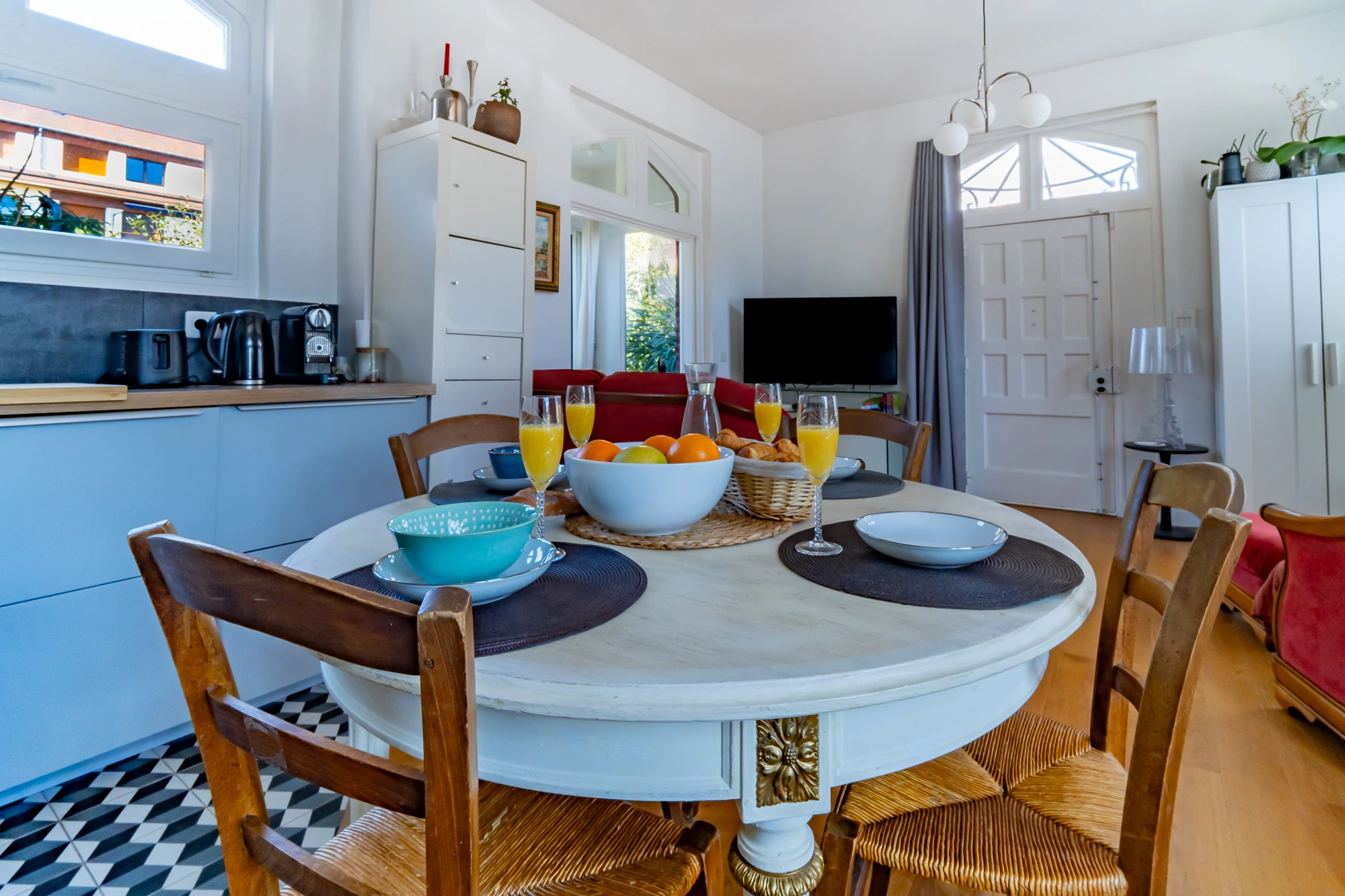 Cuisine et salle à manger – La Maison Caracas Deauville Table dressée pour le petit déjeuner avec cuisine en arrière-plan