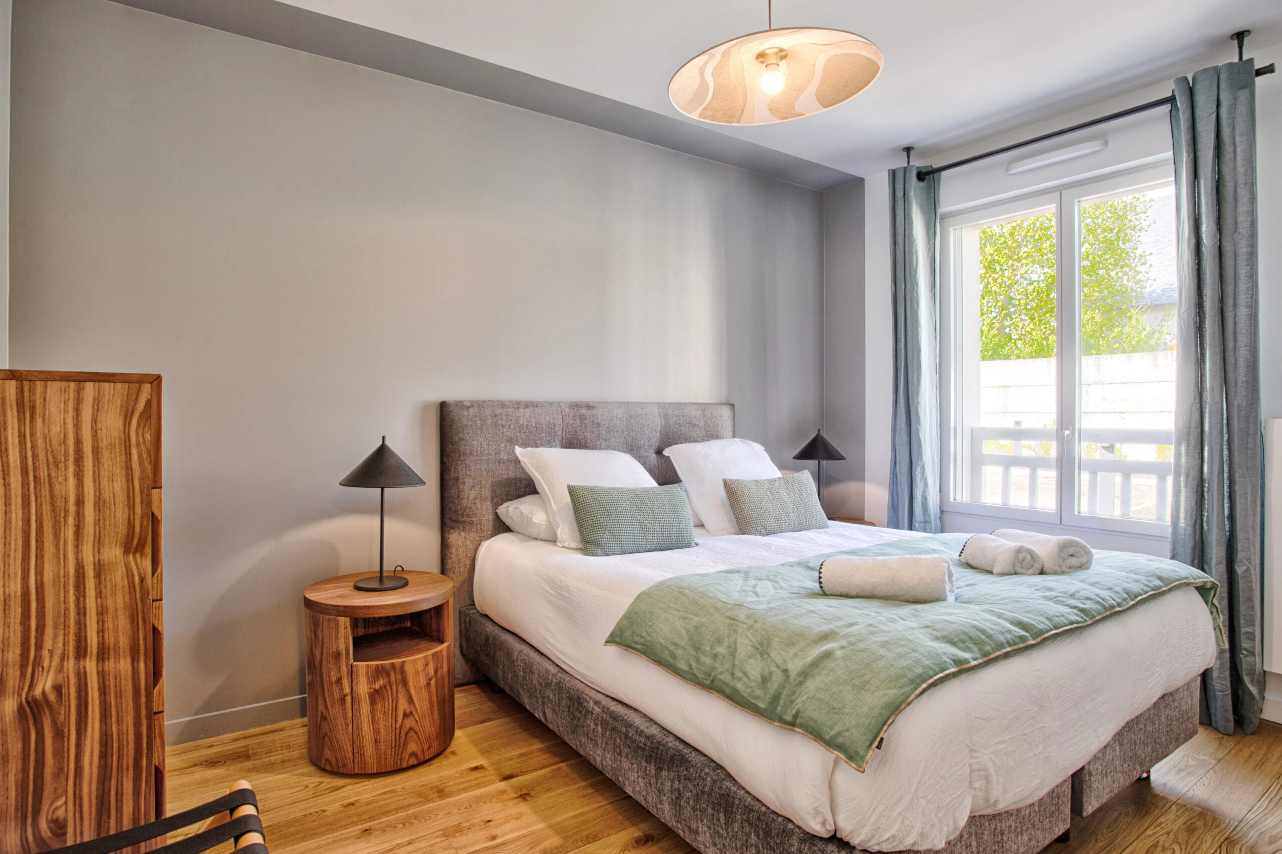 Deuxième chambre – Studio Un singe en Hiver Chambre avec mur vert, deux lampes noires et lit double bien dressé