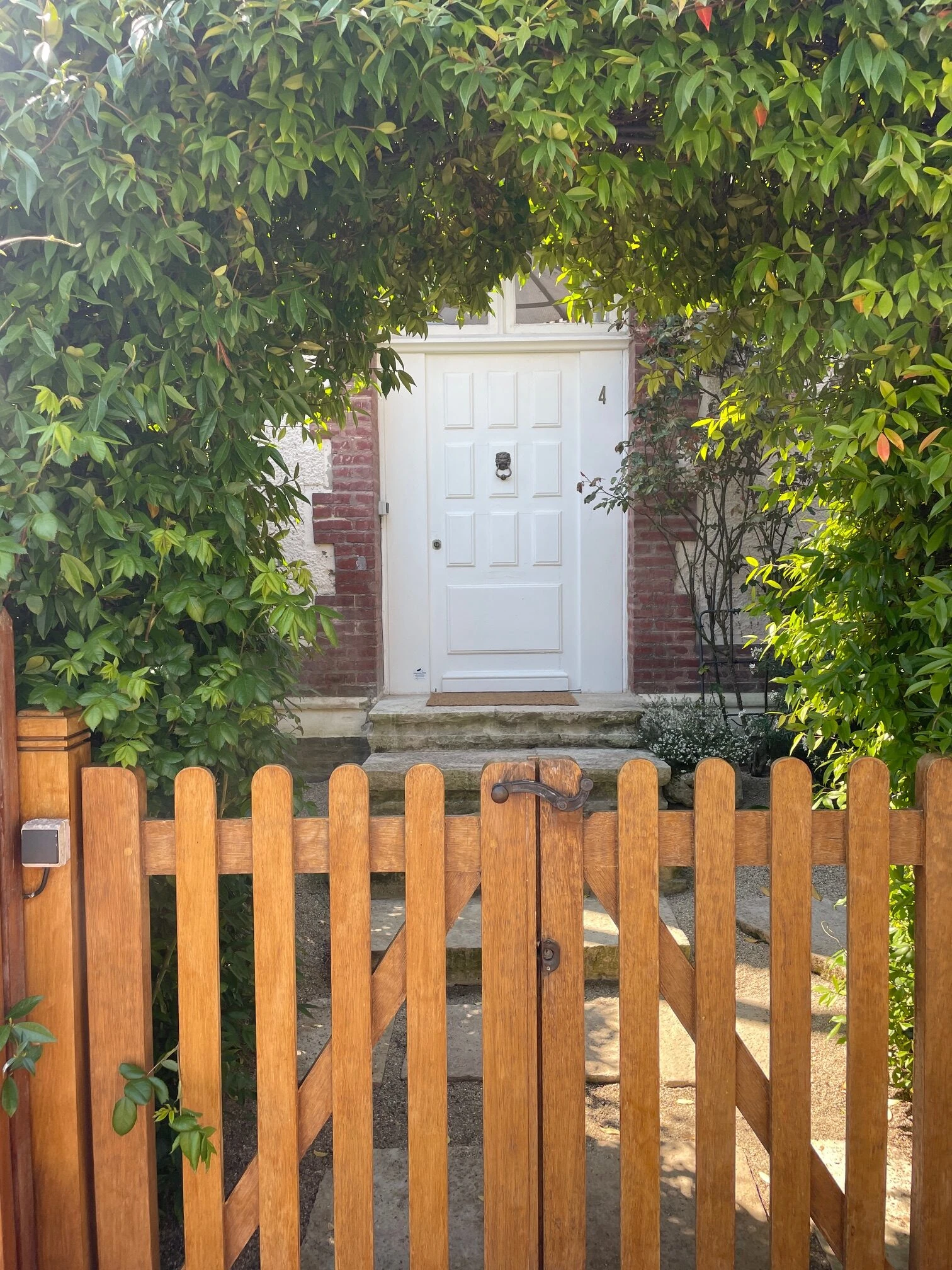 Entrée de la maison – Maison Caracas Deauville Entrée principale avec portillon en bois et végétation