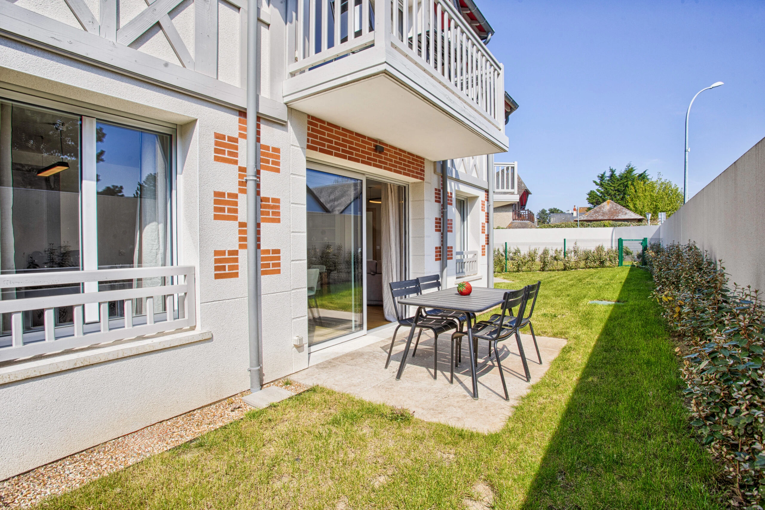 Façade extérieure et jardin – Studio Un singe en Hiver Table de jardin avec chaises noires sur terrasse dallée