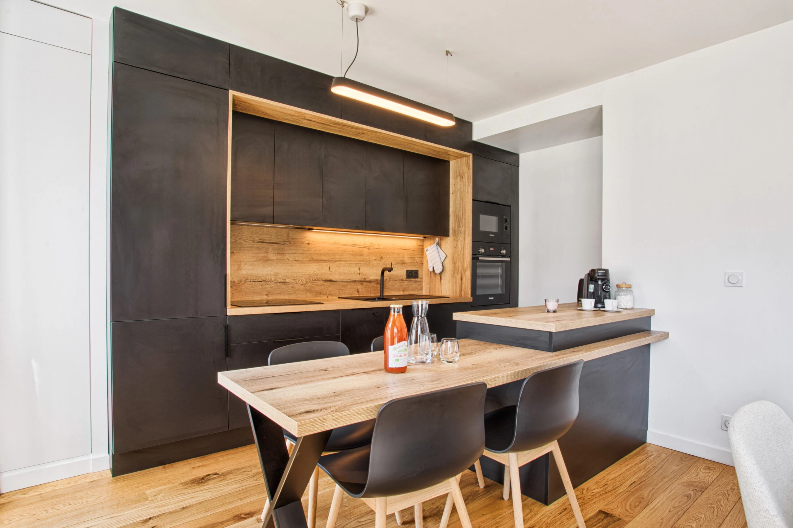 Salle à manger et cuisine – Studio Un singe en Hiver Cuisine noire ouverte sur coin repas lumineux et chaleureux