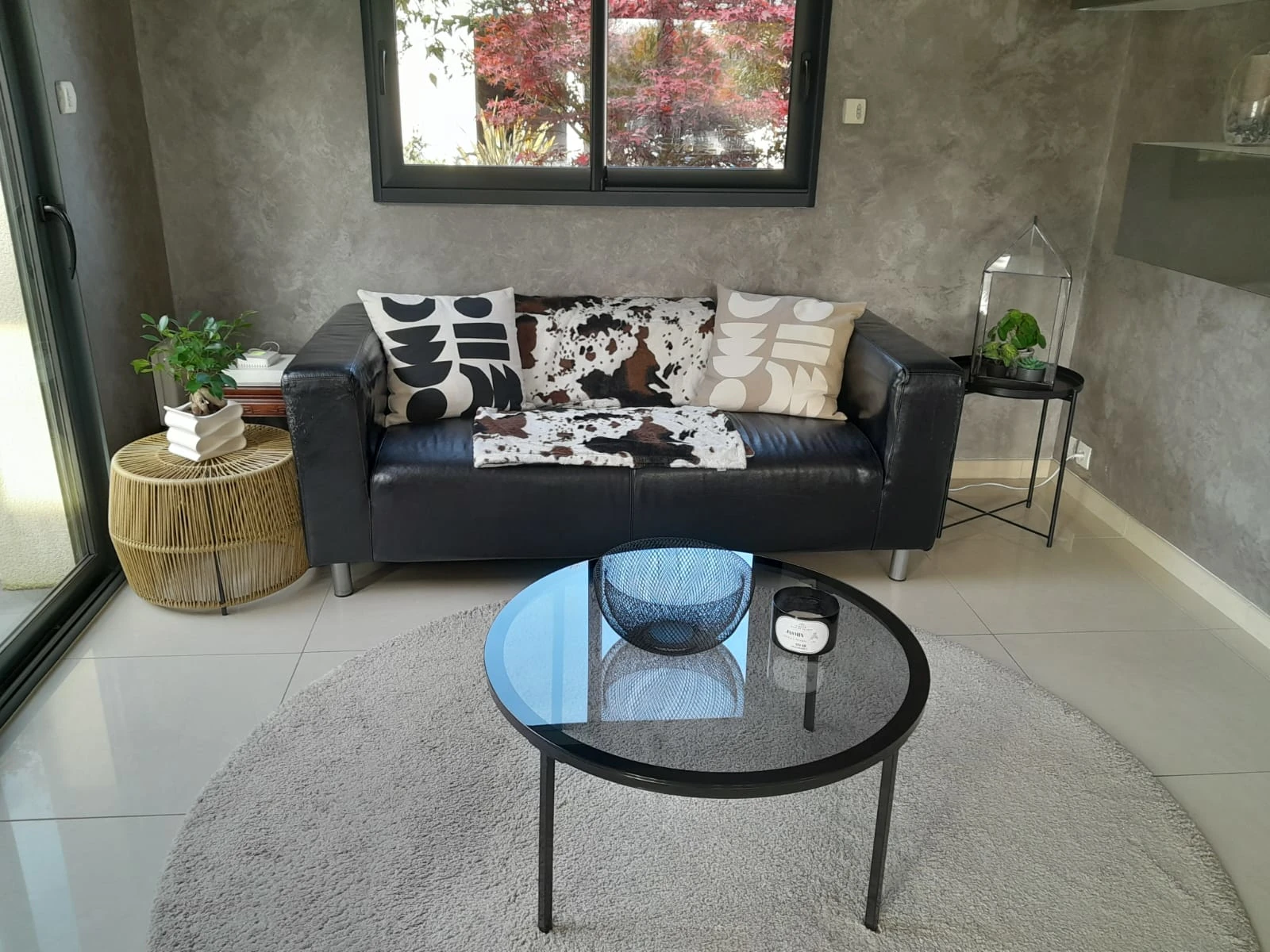 Espace de vie moderne – Les Glycines Pont L’Evêque Salon moderne avec canapé noir, table en verre et déco contemporaine, dans la location Les Glycines à Pont L’Evêque