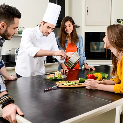Cuisinier à domicile préparant un repas raffiné pour une famille