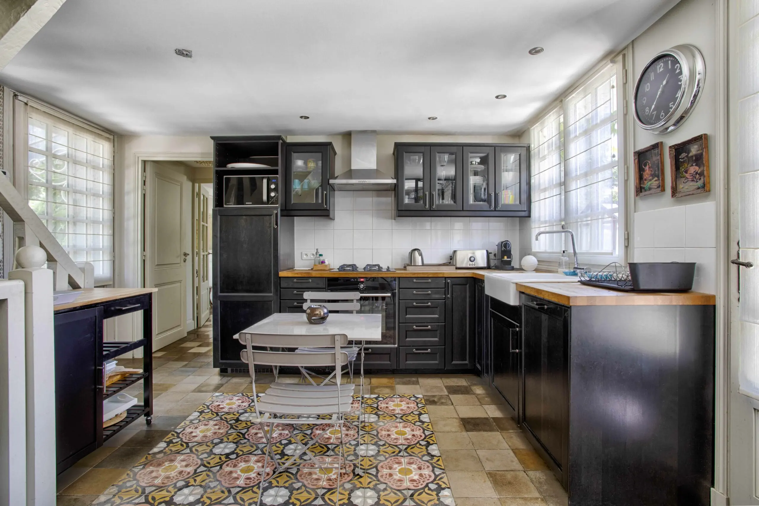 Cuisine maison d'amis Cuisine équipée haut de gamme avec façades noires et plan de travail bois massif dans une villa en conciergerie à Deauville