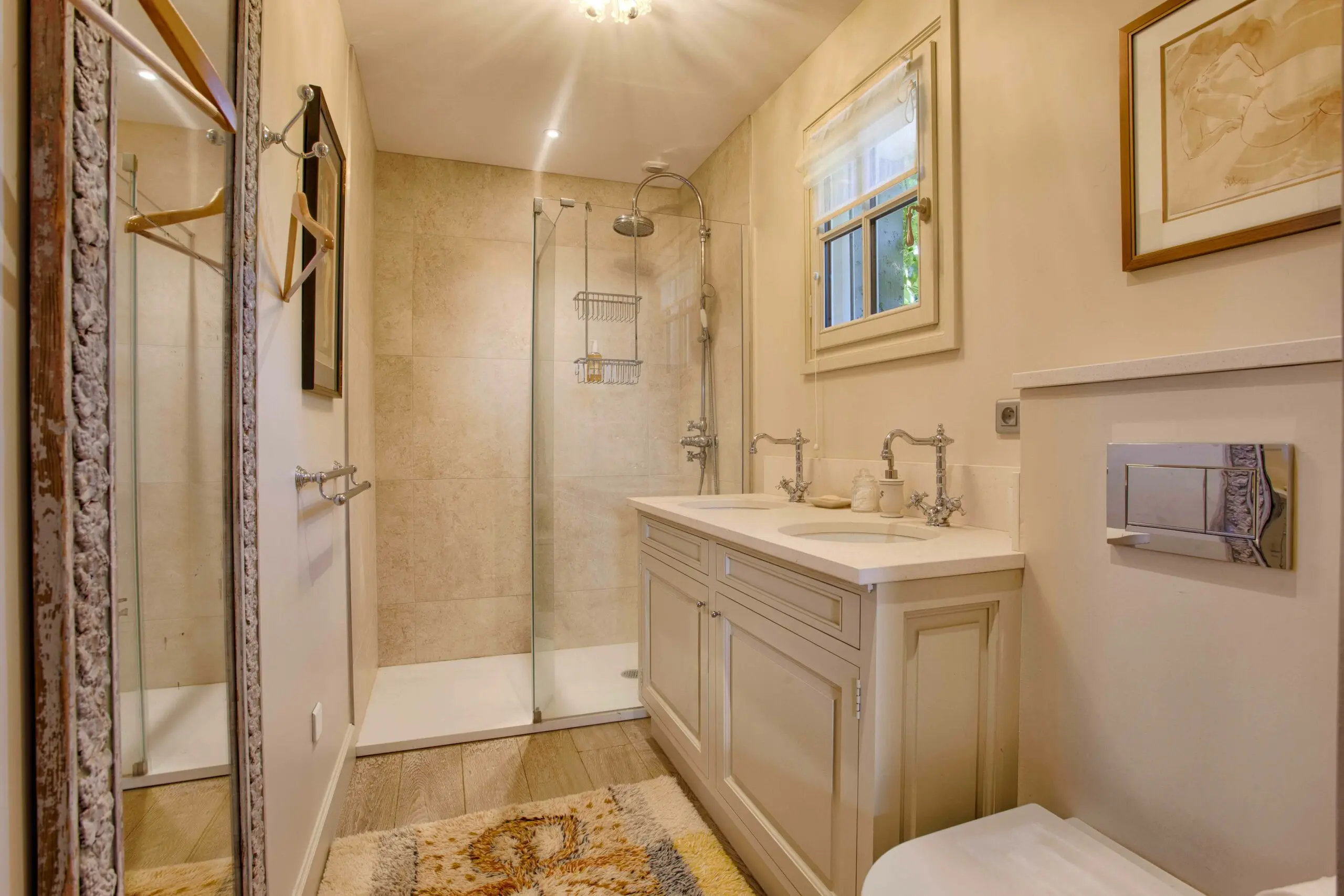 Chambre 1er - 1 Salle de bain raffinée avec douche à l'italienne en travertin et double vasque dans une villa haut de gamme en conciergerie à Deauville