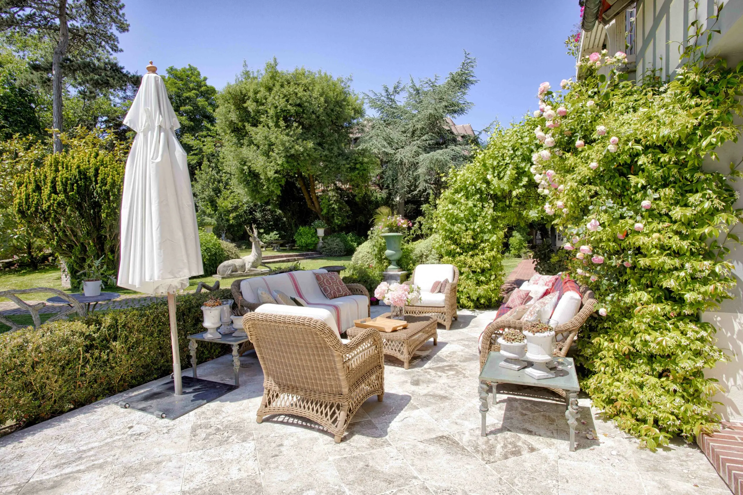Terrasse maison d'amis Espace extérieur haut de gamme avec jardin à l'anglaise et mobilier de qualité dans une propriété d'exception gérée par conciergerie à Deauville