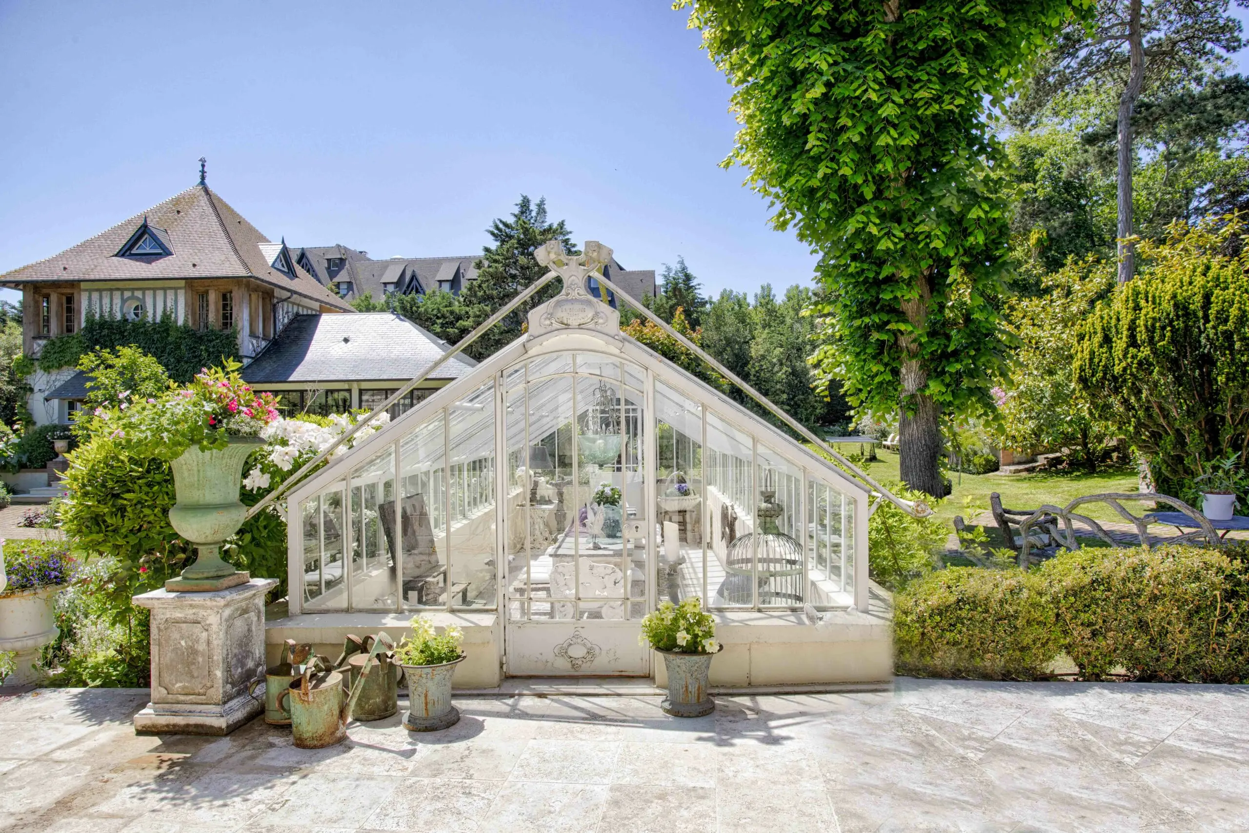 Verrière Serre victorienne ornementale dans le parc fleuri d'une villa de prestige à louer auprès de la conciergerie privée de Deauville